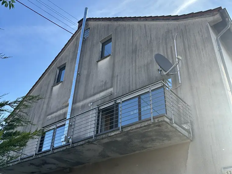 Hausfassade mit Grauschleier vor der Reinigung