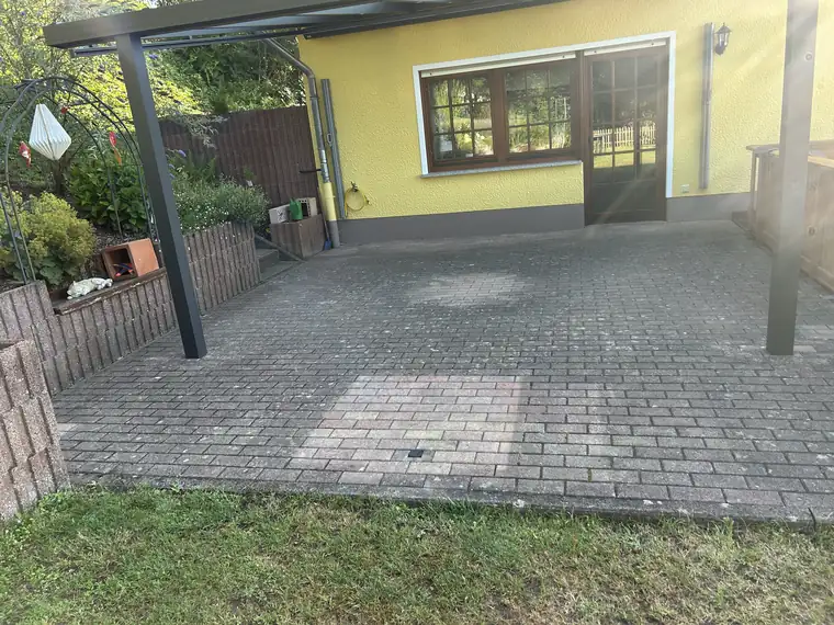Terrasse unter dem Vordach, vergraut vor der Reinigung