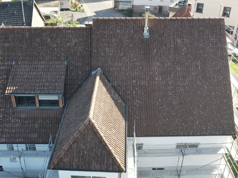 Dach eines Mehrfamilienhauses mit Moosbewuchs vor der Reinigung