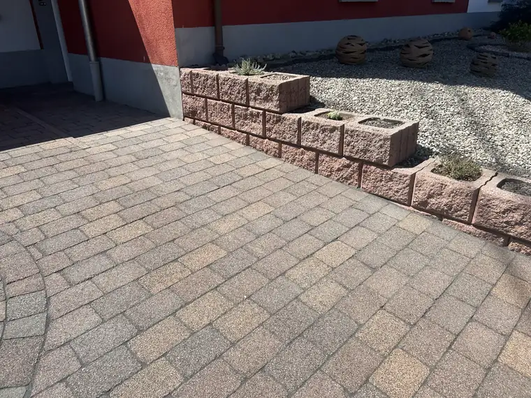 Derselbe Hof nach der Reinigung von Pflaster und Mauer